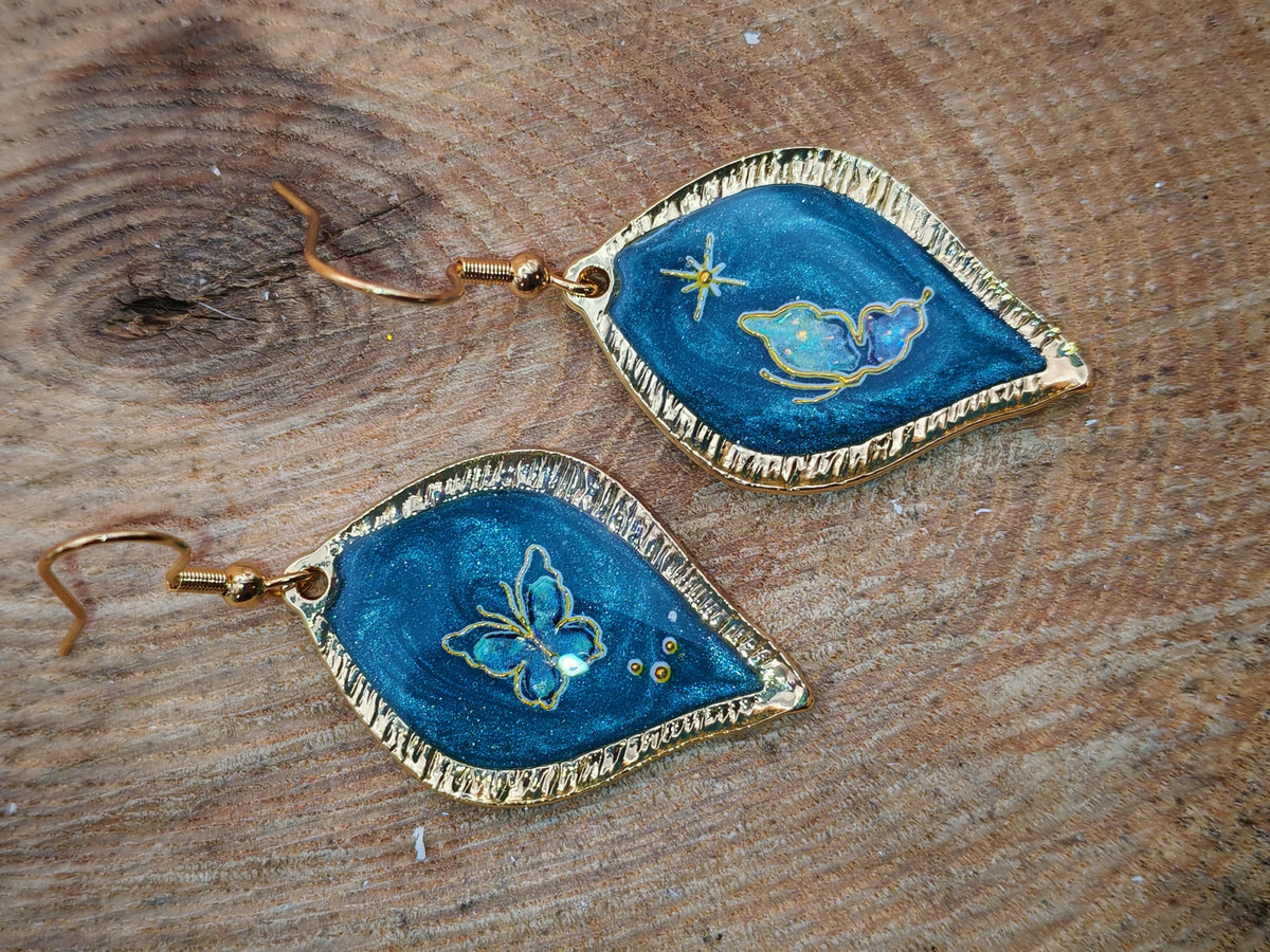 Boucles d’oreilles – Papillons dorés sur feuille céleste