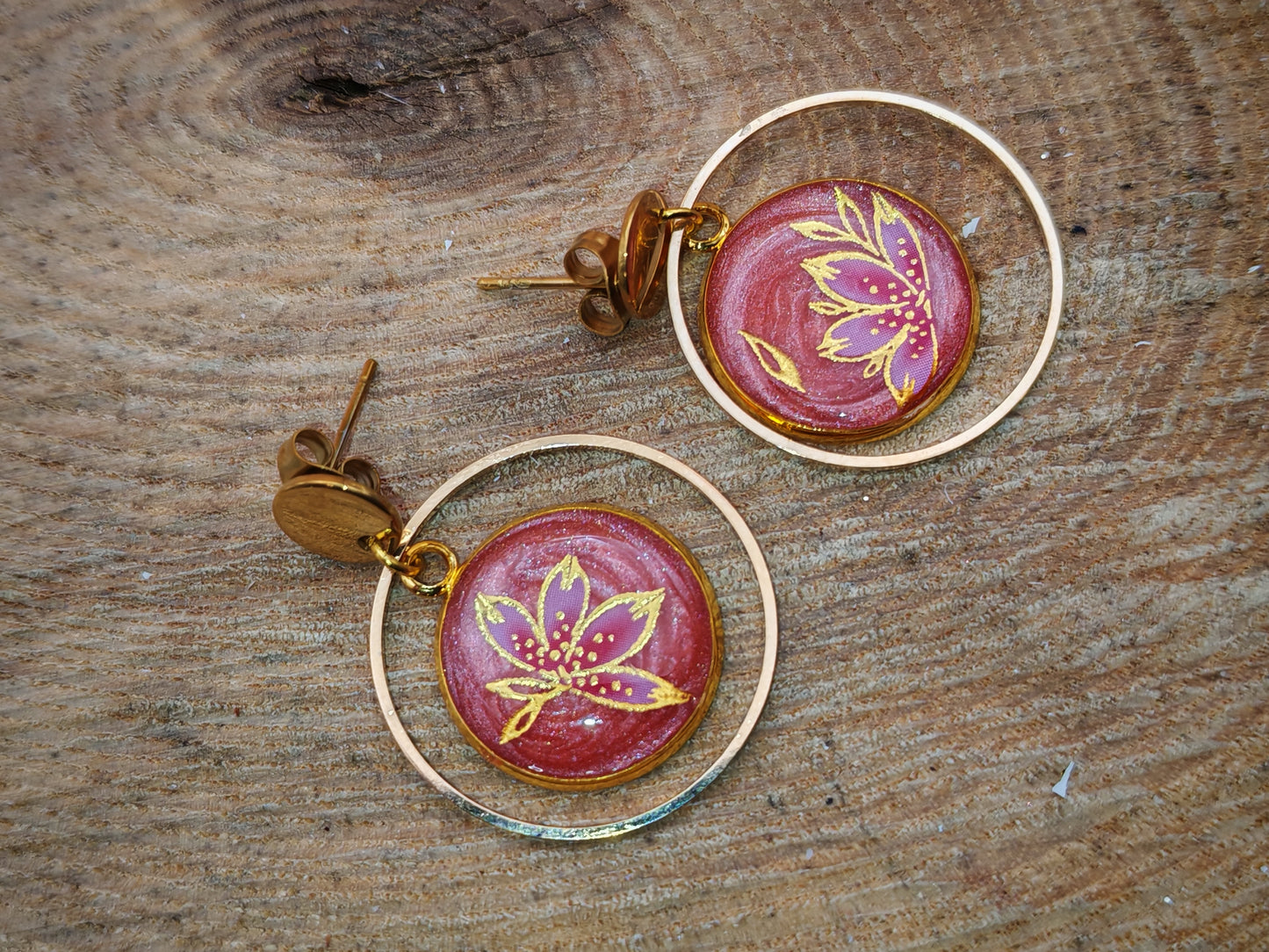 Boucles d’oreilles – Fleur rubis en cercle doré