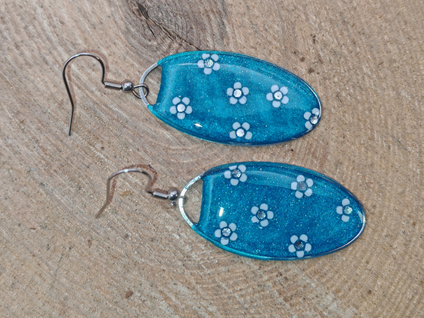 Boucles d’oreilles – Petites fleurs blanches sur fond bleu turquoise