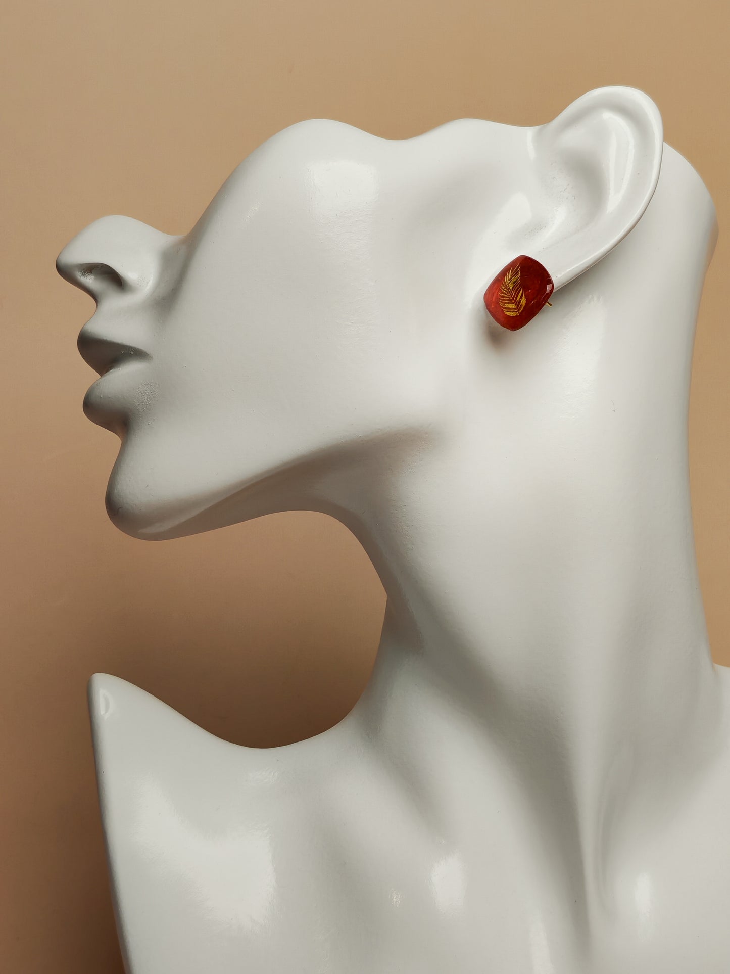 Clous d’oreille – Plume dorée sur résine rouge profonde