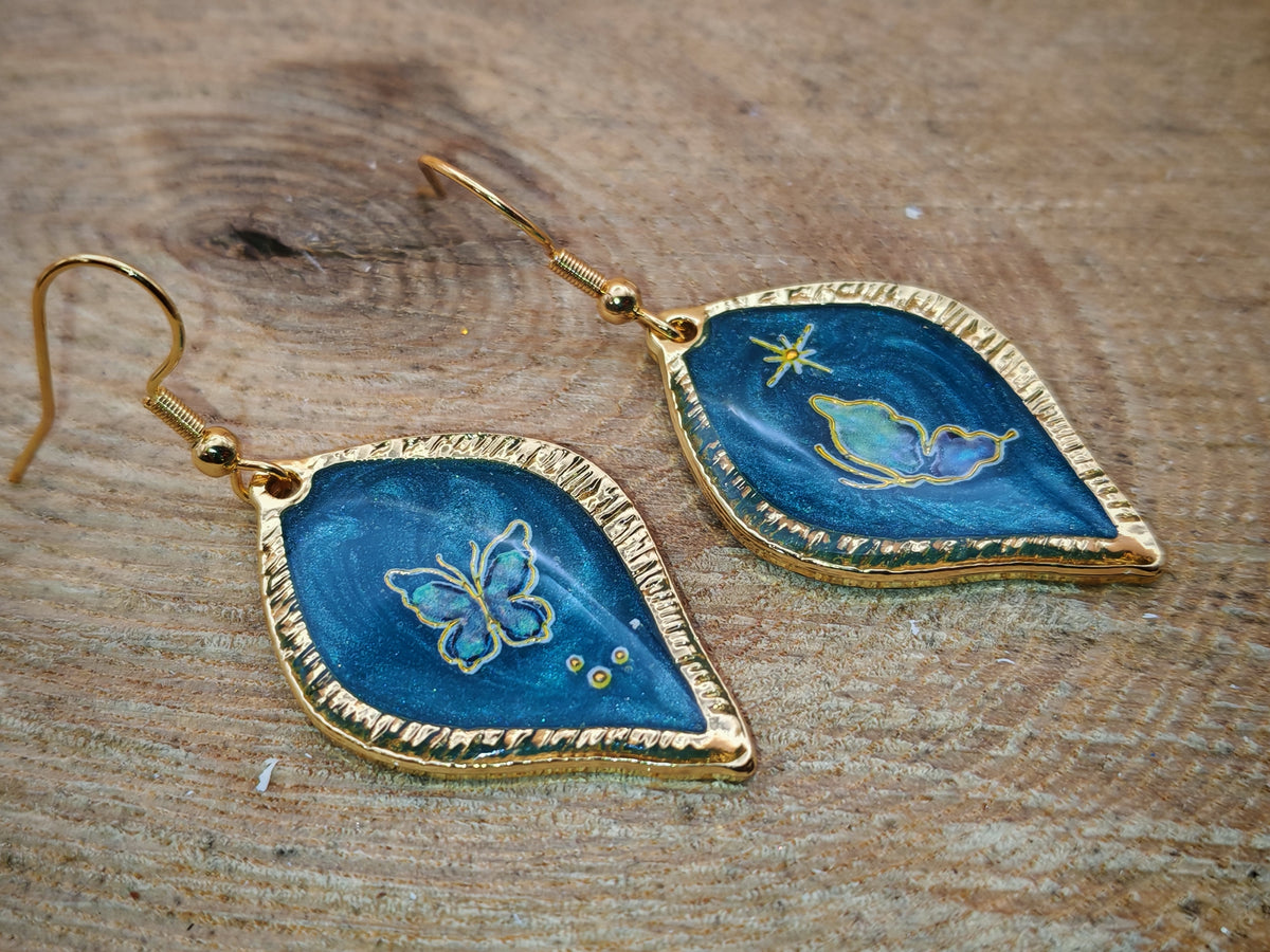 Boucles d’oreilles – Papillons dorés sur feuille céleste