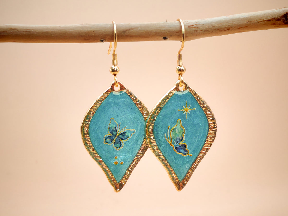 Boucles d’oreilles – Papillons dorés sur feuille céleste